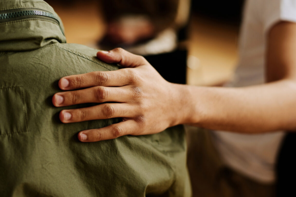 Hand on someone's back in support.