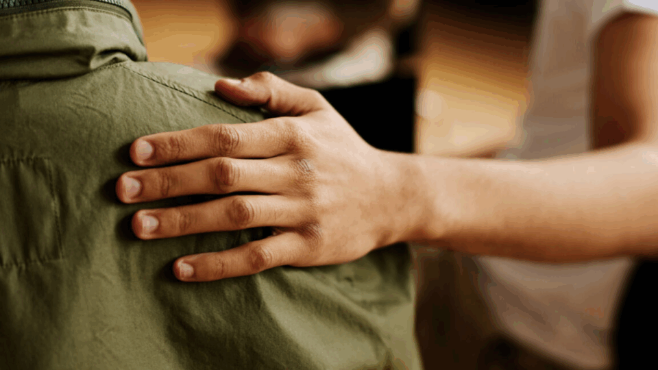 Hand on someone's back in support.