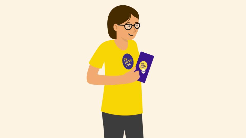 Lady wearing a Lullaby Trust t-shirt, holding a clipboard.