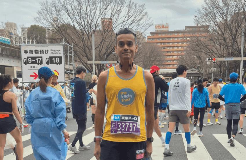 Abs in a Lullaby Trust running vest, at a running event.