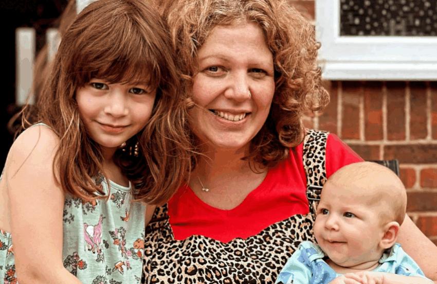 Lucy and her two children smiling at the camera.