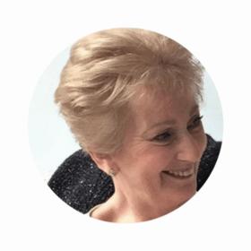 Judi, smiling looking to the side.