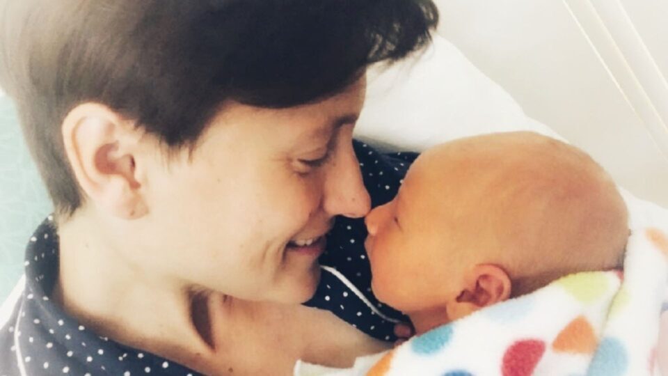 Sarah and Kit's noses are touching. Sarah is smiling.