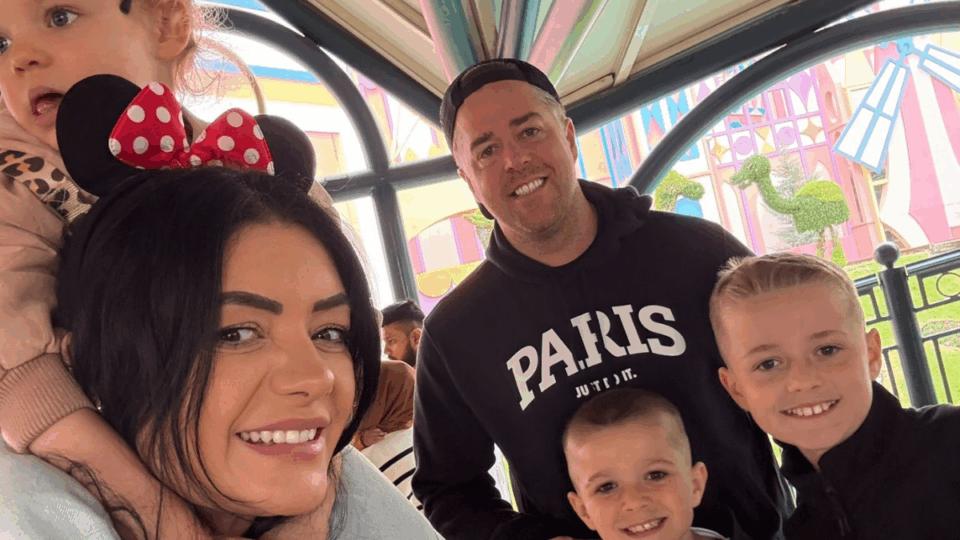 Matt and his family smiling at the camera. One person has Minnie Mouse ears on her head.