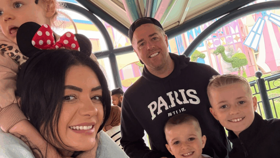 Matt and his family smiling at the camera. One person has Minnie Mouse ears on her head.