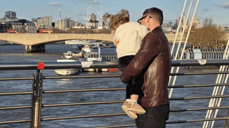 Gareth holding Aerith, looking over a barrier at a river.