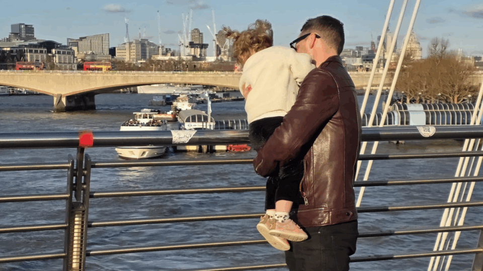 Gareth holding Aerith, looking over a barrier at a river.