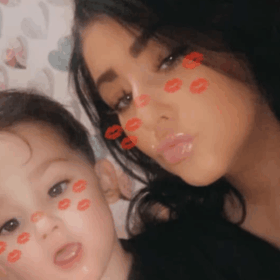 Paige and her son Freddie, with a snapchat filter on their face making at look as though they have lipstick marks on them.