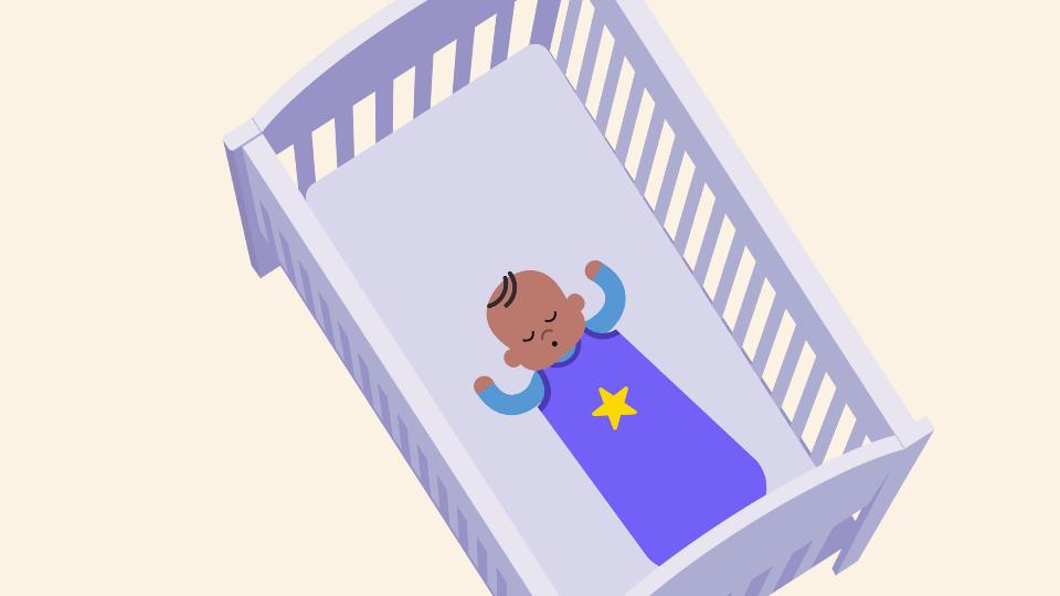 Baby in a sleeping bag sleeping at the foot of a cot.