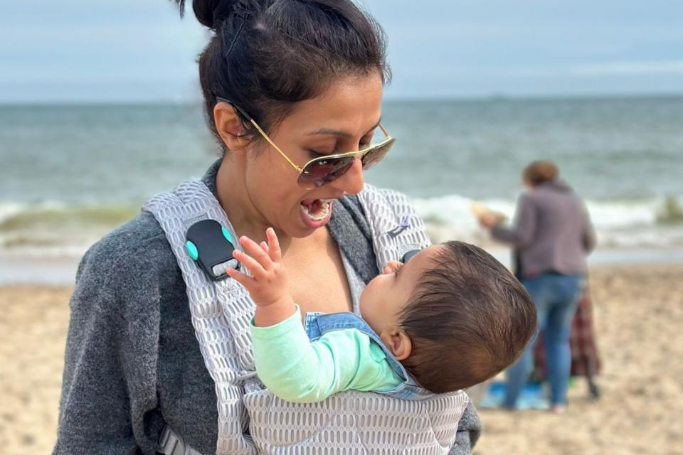 Harpal on the beach with Lara in a carrier.