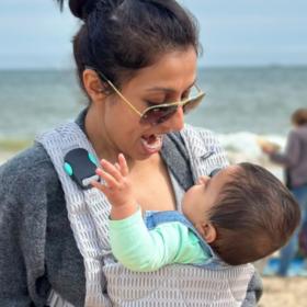 Harpal on the beach with Lara in a carrier.