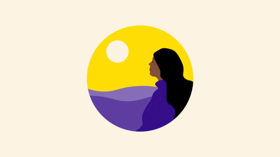 Lady looking behind her at a sunset over a landscape.