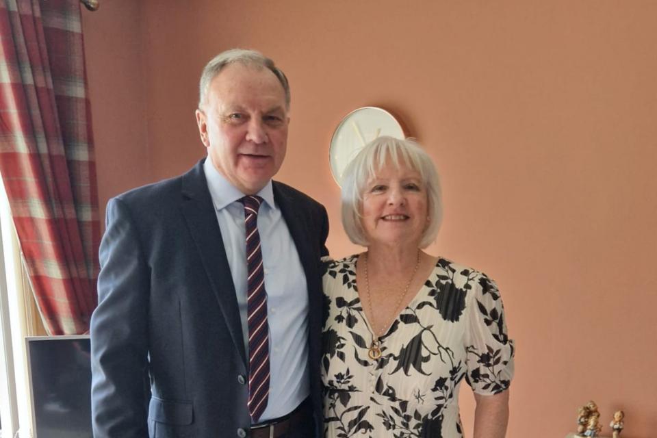 Marjorie and Ian, standing beside each other smiling at the camera