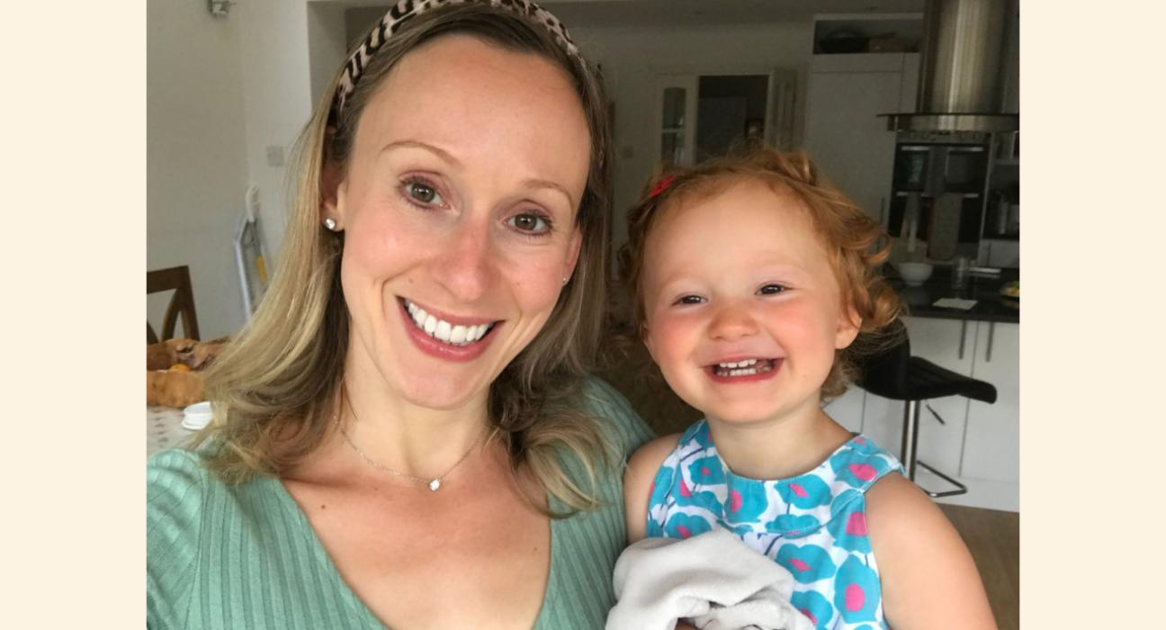 Laura and Amy smiling at the camera. Amy is wearing a flue top and has a happy face and red hair.