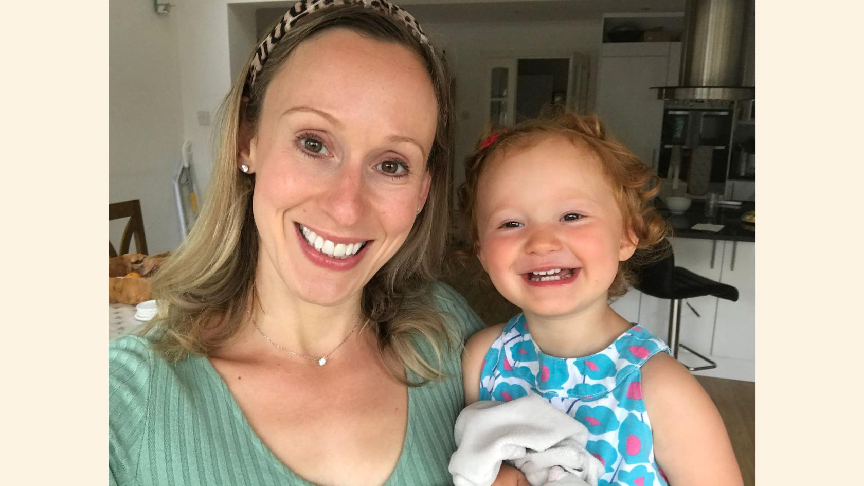 Laura and Amy smiling at the camera. Amy is wearing a flue top and has a happy face and red hair.