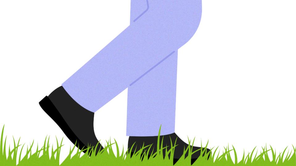 Man's feet walking on some grass