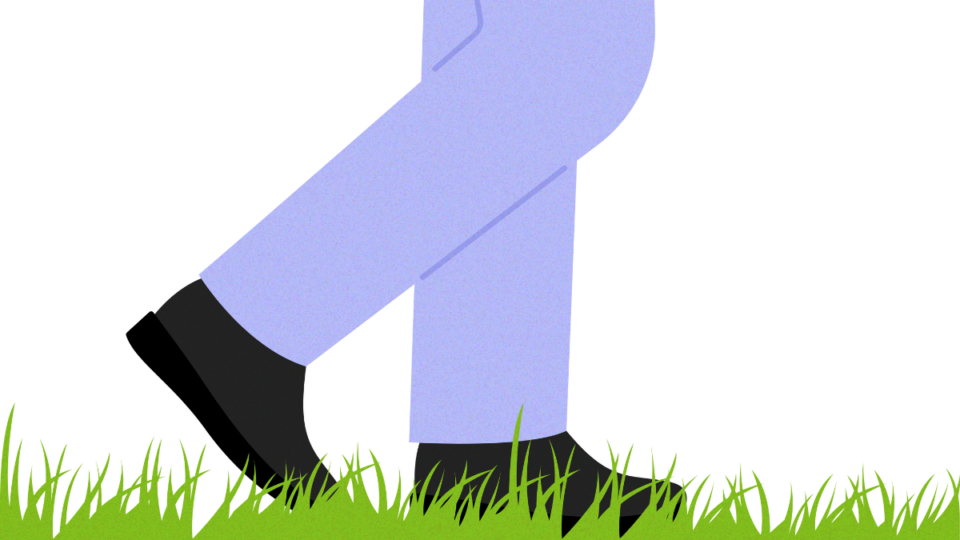 Man's feet walking on some grass