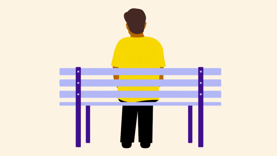 Man on bench with back to us, wearing yellow tshirt.