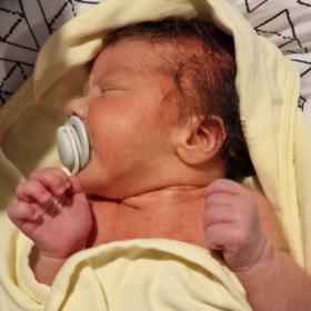 Theo with a yellow blanket and a dummy
