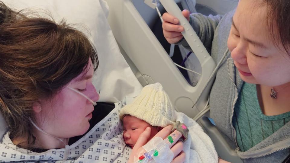 Lilly lying in hospital with Theo on her chest.