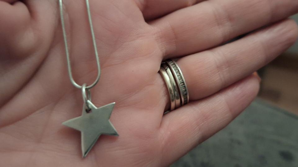 A silver necklace with a star pendant.