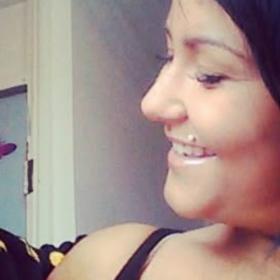 Paige holding her son, smiling at him. He has brown hair and is wearing a black top.