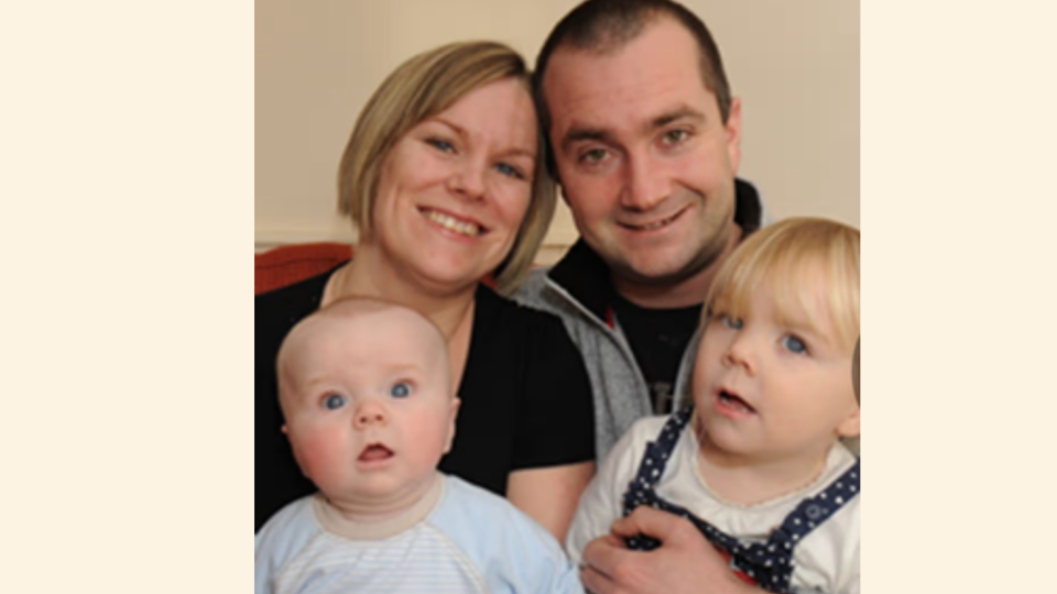 Fiona with her family. Her partner and two children all smiling at the camera.