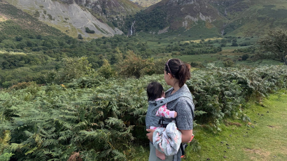 Murihah and Alannah with their back to us, looking out onto a hilly landscape.