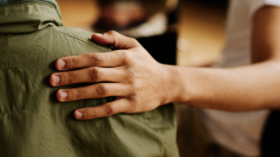 Supportive hand on someone's back.