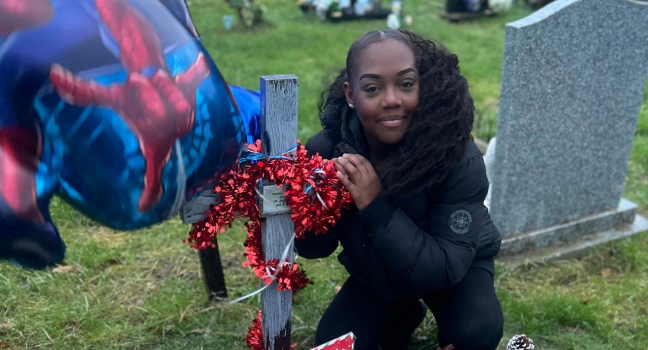 Tee at Azaiah's grave. There is a cross with red tinsel wrapped around it.