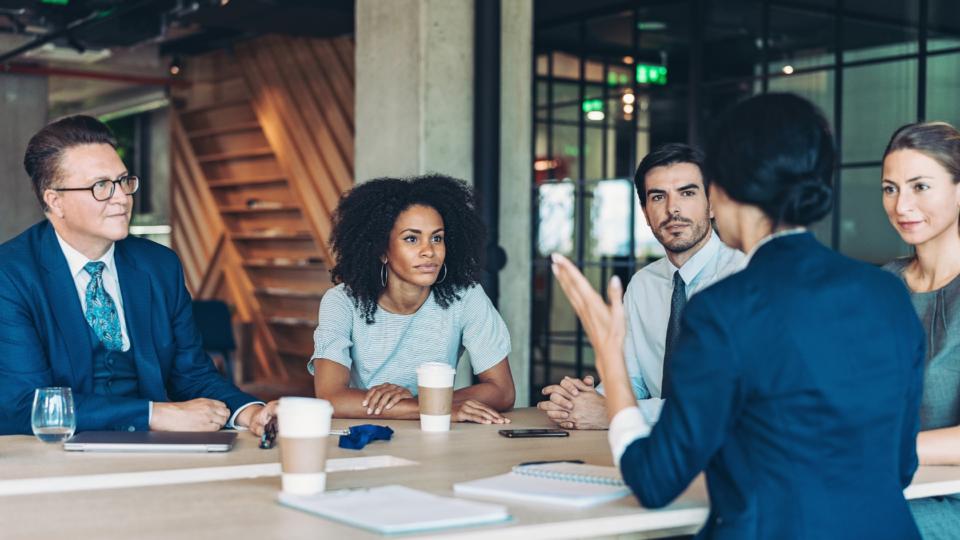 People sitting at a table in a boardroom.