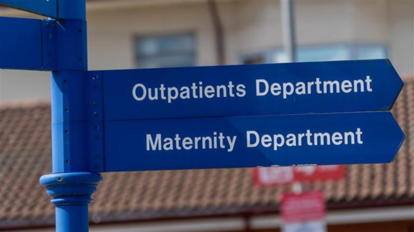 Hospital signs saying 'Outpatients department' and 'Maternity department'.