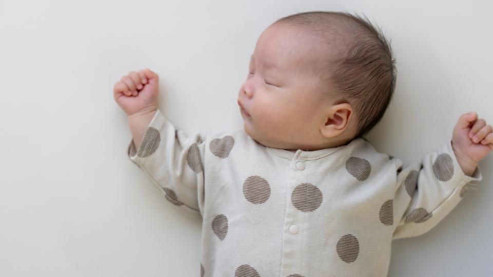 Baby sleeping on their back on a firm, flat surface.