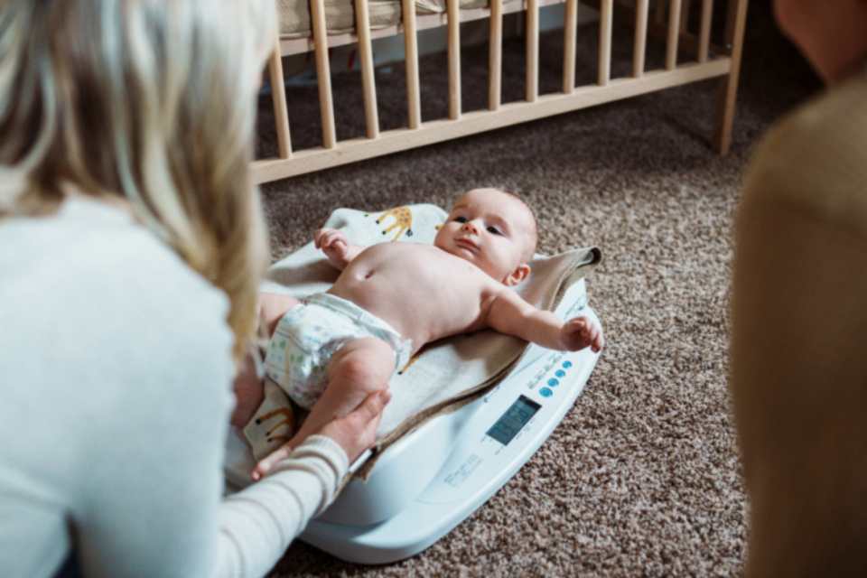Baby being weighed by a health visitor