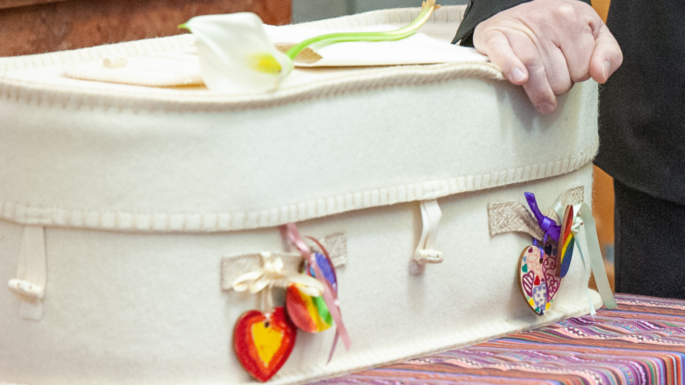 Small white box with a heart on the side at a funeral.