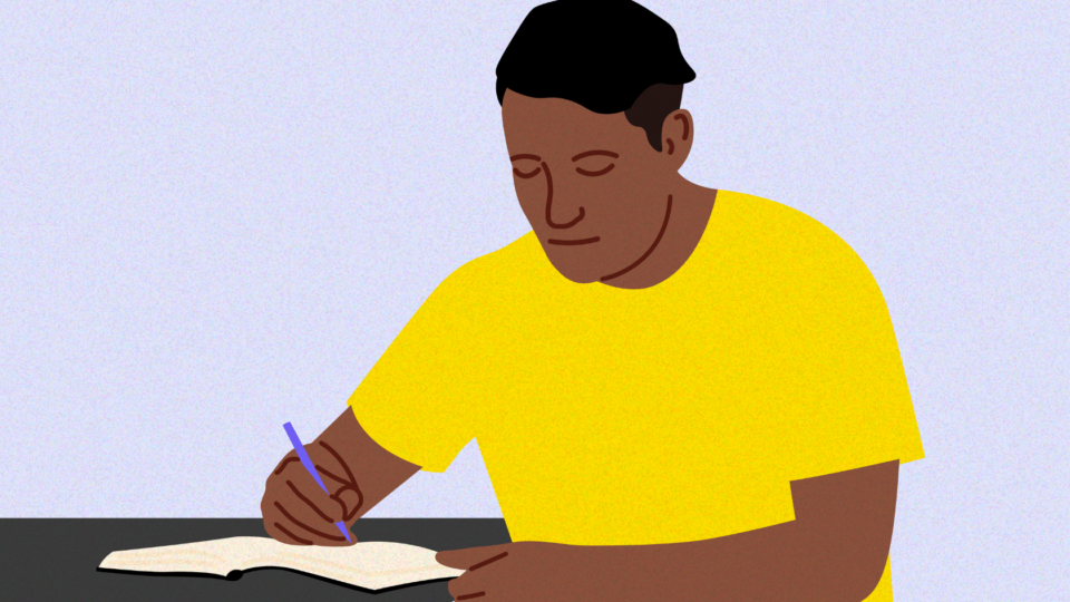 Person sitting at table writing with a pen in a notebook