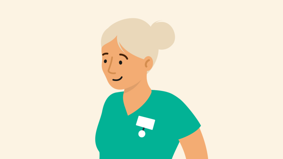 Health professional with grey hair wearing scrubs and smiling.