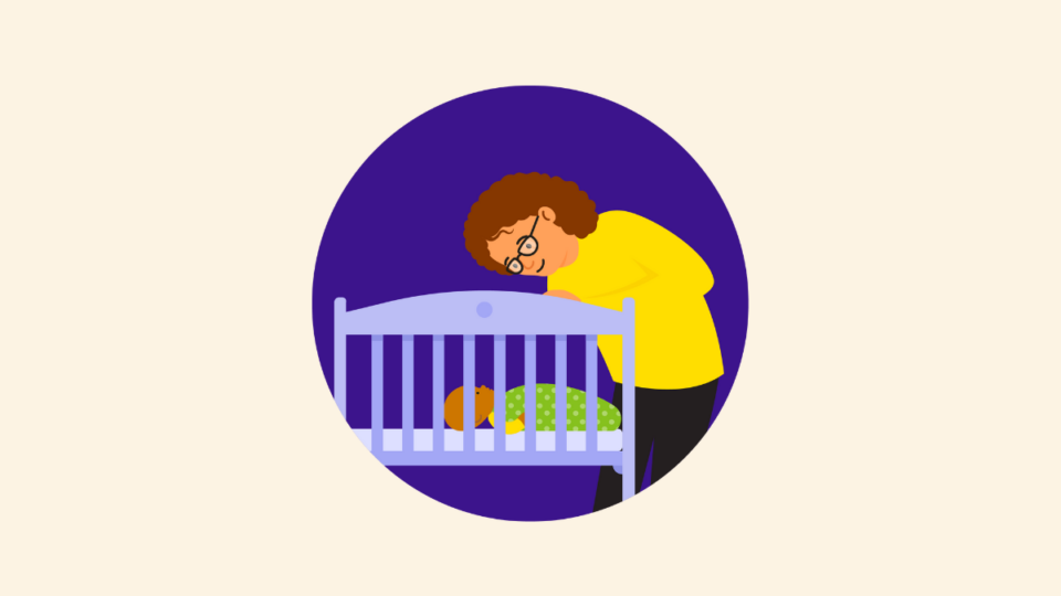 Parent looking over cot with baby in, wearing a sleeping bag.