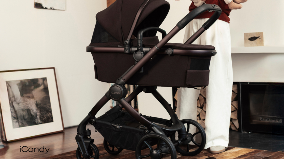 A brown pushchair with a carrycot indoors on a wooden floor
