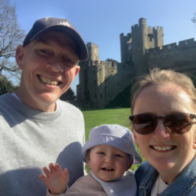 Mark taking a selfie, smiling at the camera on a sunny day with his fiancee May and his son Malyn.