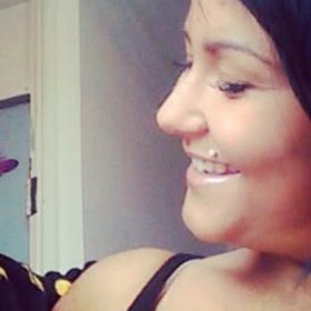 Paige holding her son, smiling at him. He has brown hair and is wearing a black top.