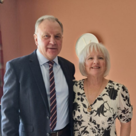 Marjorie and Ian, standing beside each other smiling at the camera