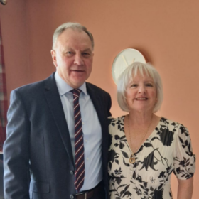 Marjorie and Ian, standing beside each other smiling at the camera