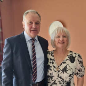 Marjorie and Ian, standing beside each other smiling at the camera