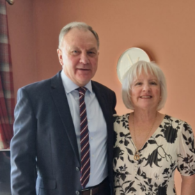 Marjorie and Ian, standing beside each other smiling at the camera