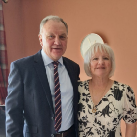 Marjorie and Ian, standing beside each other smiling at the camera