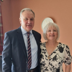 Marjorie and Ian, standing beside each other smiling at the camera