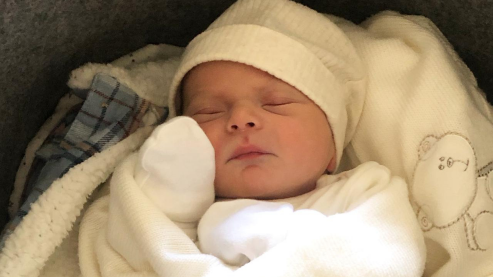 Ezrah asleep with a white hat on.