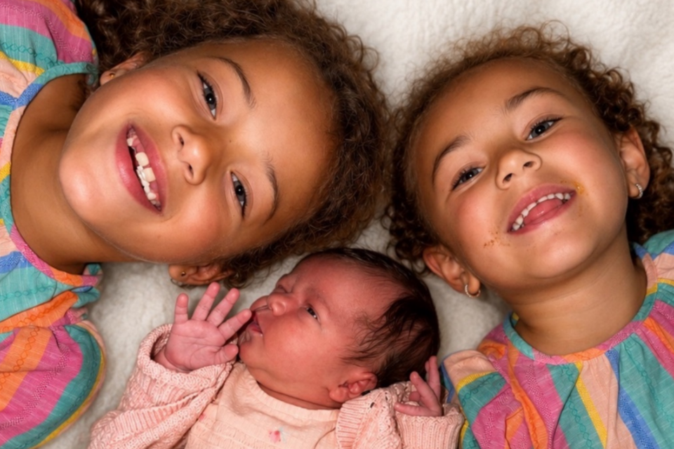 Nevaeh, Niyah and Naleyah, lying down all smiling up at the camera.