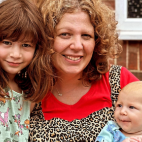 Lucy and her two children smiling at the camera.